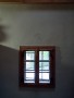 Hliněná omítka s decentním dekorem nad oknem