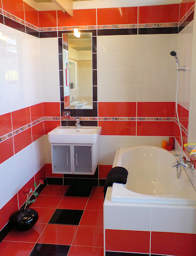Menší koupelna s červenobílými obklady